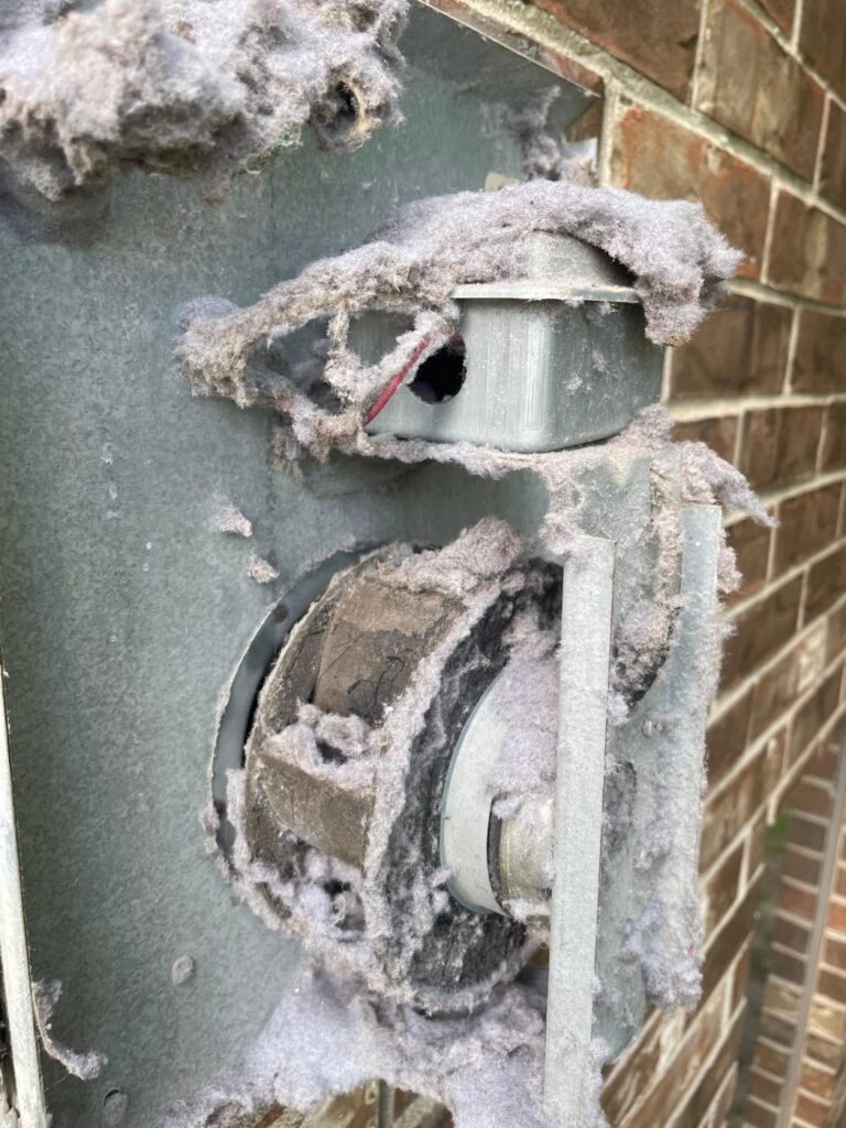 Exterior dryer booster fan caked in lint buildup before cleaning in Brookshire, TX 77423