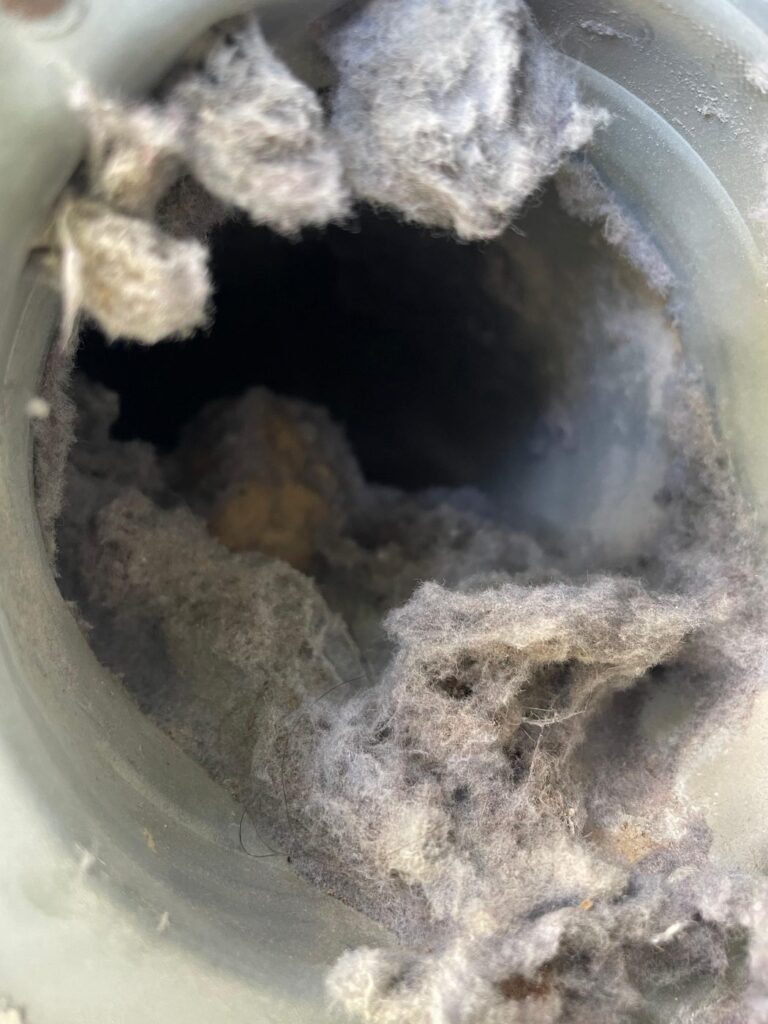 Heavy lint clog inside a dryer vent duct before cleaning in Brookshire, TX 77423