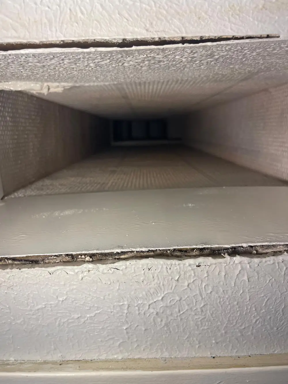 Supply vent opening showing clean coated duct board after air duct cleaning in Katy TX