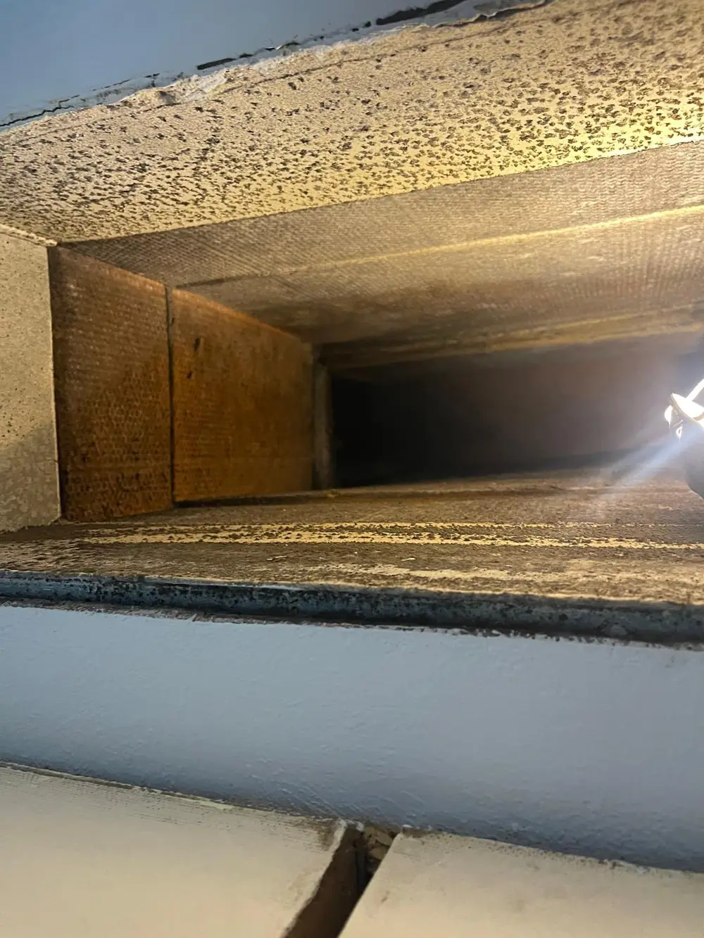 Dirty fiberglass duct board interior with heavy surface contamination before cleaning in Katy TX home